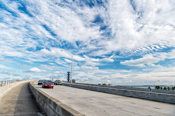 highway with skyscrapers on blue cloudy sky