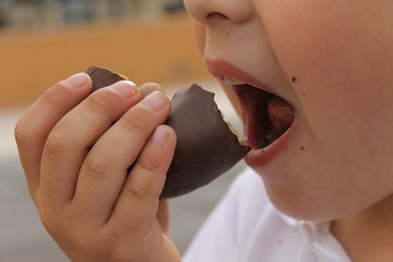 Boca de niño comiendo pastel de chocolate