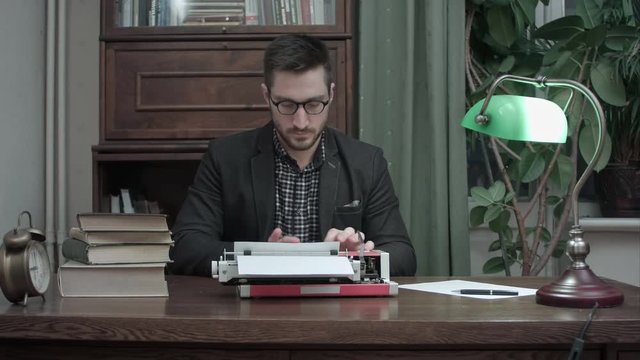 Satisfied writer in glasses finishing typing another chapter of his book