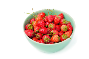 Fresh ripe strawberries in small green bowl on white background.