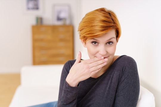 frau hat ein geheimnis und hält die hand vor den mund