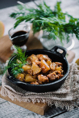 Roasted chicken with apples served with fresh dill in black iron pan