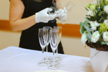 The waiter places clean glasses