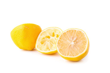 glass bowl of freshly squeezed lemon juice, lemon squeezer and ripe lemons on white background