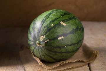 watermelon and watermelon pieces in a wooden background