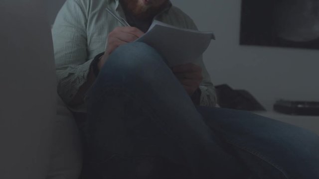 Young filmmaker writing his notes on a storyboard. 4K UHD