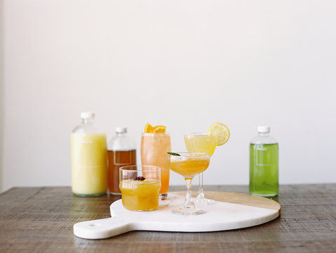 Row of citrus fruit cocktails and ingredients