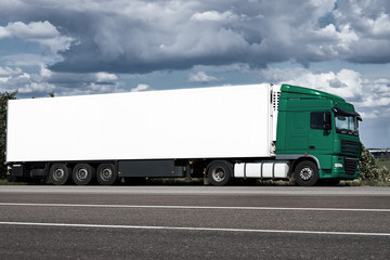 Fototapeta na wymiar Truck on road with white blank container, blue sky, cargo transportation concept