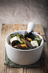 Seafood and tofu stew in a claypot. Wooden rustic background 