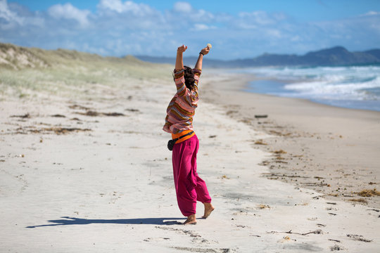 Happy young woman on beach, New Zealand
