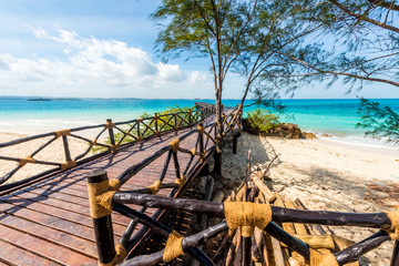 beautiful landscape with wooden pier leading to the clear blue ocean on Turtles Island, Zanzibar