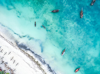 top view of ocean with fishing boats and islad city coastline on Zanzibar, aerial photo