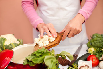 Preparing of raw cauliflower in the kitchen dish