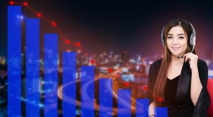 asian woman support phone operator or call center in headset sitting on red chair with trading graph on blurred night city background, business and broker financial concept, color tone effect.