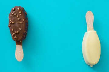 Black and white chocolate ice cream popsicles on blue background. 
