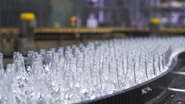 beer production line in the workshop. Bottles Moving Along the Conveyor Line. Glass manufacturing machine. Close-up