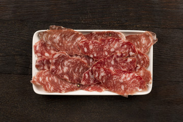 Italian salami sliced and arranged on a rectangular plate