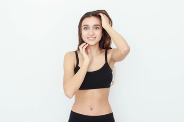 Fototapeta premium Beautiful girl in black top on white background shows emotion