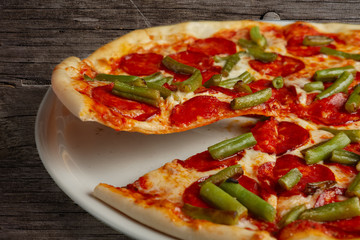 Slice of pizza pepperoni on scapula. Levitatating piece of pizza.