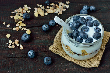 Fresh white yogurt with blueberries and oatmeals on brown wood table. Delicious natural breakfast. Culinary sweet dessert.