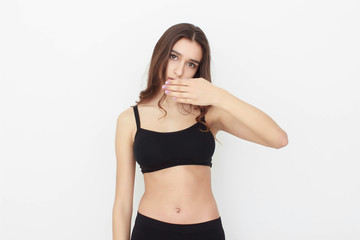 Beautiful girl in black top on white background shows emotion