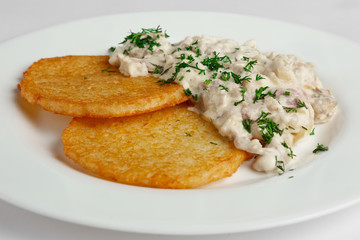 Close up of draniki with mushroom and cream sauce