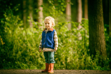 Little caucasian boy playing outdoor in summer.