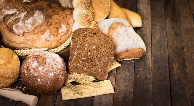 Assortment of baked bread on wooden table