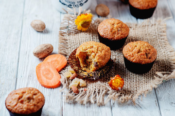 hearty and healthy breakfast, lunch, pastries, carrot cupcakes with raisins, candied fruits, nuts and green tea on a wooden background 