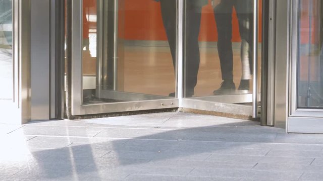 People Enter and Exit a Commercial Office Through a Sliding Door in the Modern City
