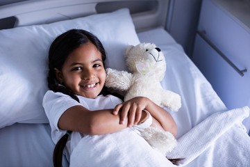 Portrait of patient relaxing on bed with teddy bear