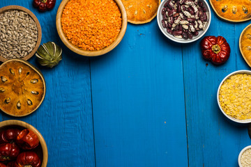 Bowls and spoons of various legumes on wooden table