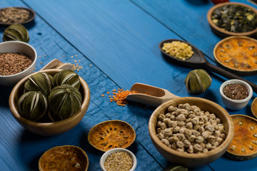 Bowls and spoons of various legumes on wooden table
