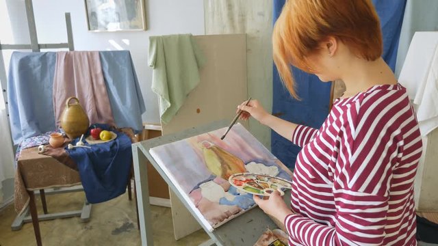 A young artist in an art workshop draws a still-life from nature in watercolor.
