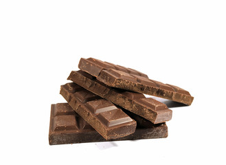 Piled Up Pieces of Dark Chocolate Bar Isolated on White Background