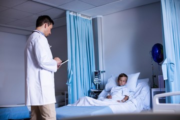 Doctor using digital tablet in ward