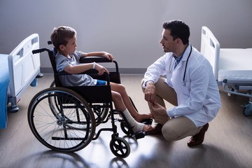 Male doctor interacting with child patient in ward