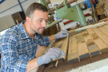 Carpenter aligning planks of wood