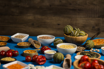 Bowls and spoons of various legumes on wooden table