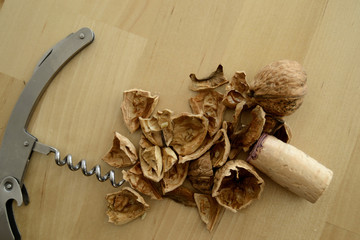 Steel corkscrew, cork, and walnut on wood background