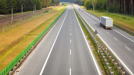 Panoramic picture of a lorry on almost empty highway.