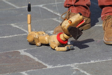 Traditional puppets made of wood. Puppet to form of dog moved by man.