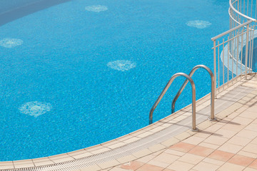 Beautiful luxury swimming pool with grab bars ladder
