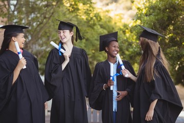 Graduate school kids standing with degree scroll 