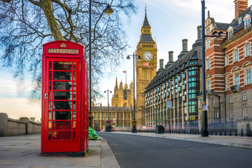 Fototapeta premium Londyn, Anglia - kultowa brytyjska stara czerwona budka telefoniczna z Big Benem w tle w centrum Londynu