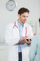 doctor taking notes to diagnose patient