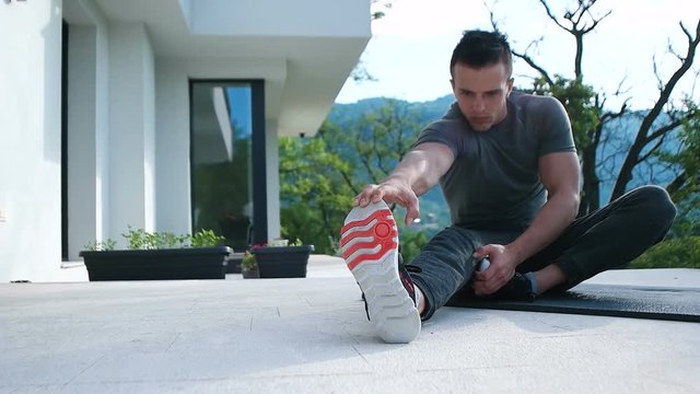 man doing exercise on terace in front of villa