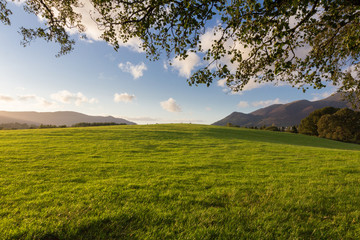 Sunset over picturesque green fields and hills of Kenswick's Valley in Lake District, UK