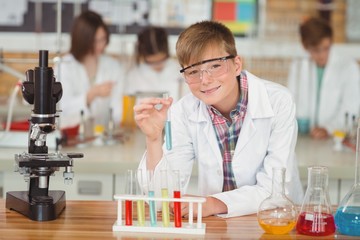 Portrait of schoolboy doing a chemical experiment in laboratory