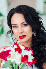 Fototapeta na wymiar gorgeous bride with fashion makeup and hairstyle in a luxury wedding dress . Red lips